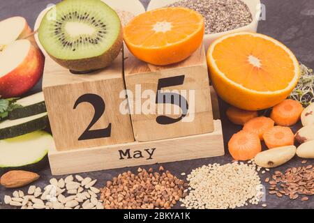 Calendario cubo con data del giorno Mondiale della tiroide e il miglior cibo contenente minerali naturali e vitamine per la tiroide sana Foto Stock