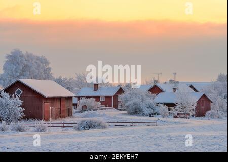 Inverno in un villaggio con tradizionali case rosse di falu, Hulla, Österåker, Vingåker, Södermanland, Svezia Foto Stock