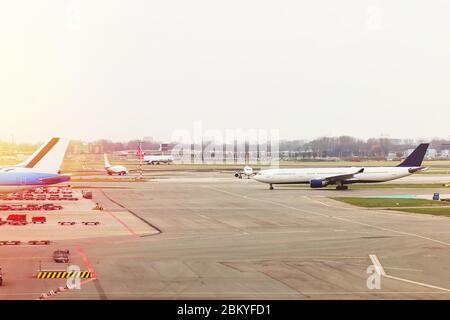 Aeroporto con aeroplani al cancello del terminal pronto per il decollo, aeroporto internazionale durante il tramonto Foto Stock