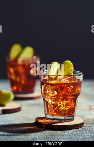 Cocktail di whisky al succo di mela sotto la luce del sole (foto con messa a fuoco morbida e profondità di campo bassa) Foto Stock