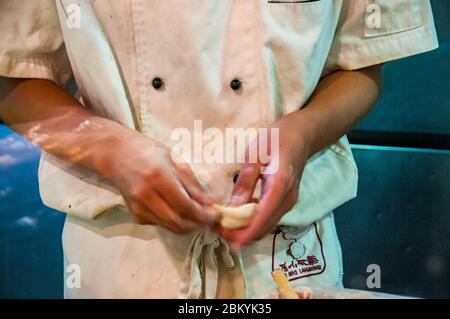 Uno chef rendendo xiaolongbao (zuppa gnocchi) in un piccolo ristorante a Shanghai. Foto Stock