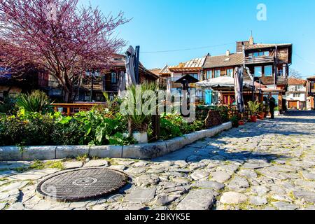 Nessebar, Bulgaria. Aprile 26, 2013. Manhole e ciottoli sulla strada della città vecchia in sole primavera giorno Foto Stock