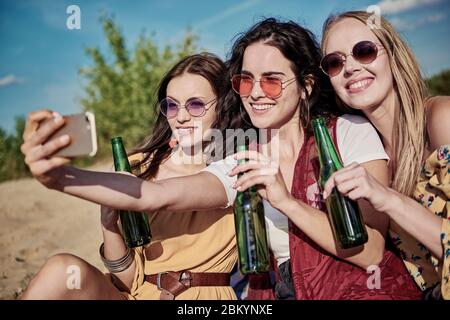 Tre giovani donne belle fare un selfie sulla spiaggia