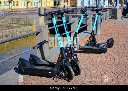 Scooter elettrici o e-scooters a livello parcheggiati nell'area pedonale della città. Helsinki, Finlandia. Aprile 22, 2020. Foto Stock