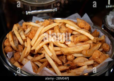 Patatine fritte e spicchi di patate fritte in un grande vassoio a buffet Foto Stock