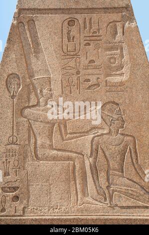 Dettaglio di vestigia di sculture geroglifiche sulla cima dell'obelisco presso l'antico tempio egiziano di Karnak a Luxor Foto Stock