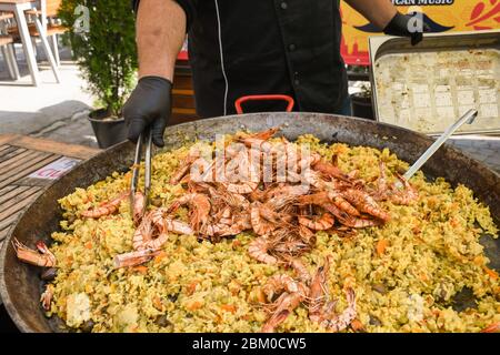 Paella di pesce cucinata in un grande padella wok, festa del cibo di strada. Specialità del piatto nazionale della festa messicana. Stazione di cottura dal vivo. Buffet di cibi freschi, Fr Foto Stock