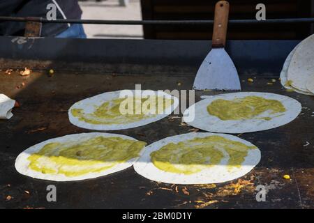 Il processo di preparazione di un quesadilla, piatto tradizionale messicano. Ambiente esterno all'aperto, cucina dello chef durante il festival del cibo, autentico cibo di strada. BL Foto Stock