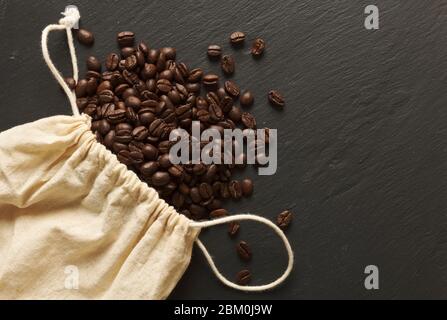 Caffè macinato fresco su un sacco di stoffa su un ardesia di pietra grigia Foto Stock
