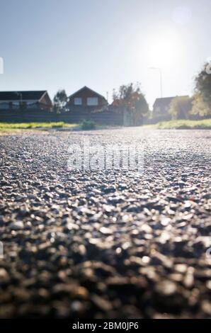 Immagine di basso livello delle case britanniche e del tarmac marciapiede in un giorno luminoso in Kent, Inghilterra Regno Unito Foto Stock