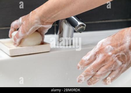 donna è lavando le mani con sapone Foto Stock