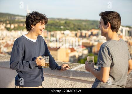 Due giovani che bevono sul tetto Foto Stock