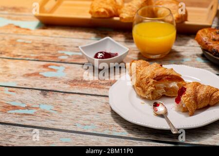 Colazione continentale con croissant su tavolo rustico Foto Stock