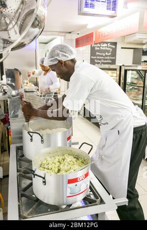 Johannesburg, Sudafrica - 22 novembre 2016: Il personale dello chef maschile africano che lavora nella cucina della sezione di macelleria e deli presso il locale Pick n Pay Grocer Foto Stock