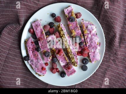 Barrette di yogurt surgelate rosa fatte in casa con lamponi e mirtilli. Snack per i giorni estivi Foto Stock