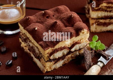 Servizio di tiramisù appena fatto con contorno di menta e polvere di cacao in una vista ravvicinata ad angolo alto per la pubblicità del menu Foto Stock