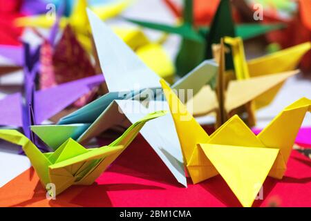 La carta si grana da carta multicolore. Origami giapponese da carta colorata.Origami colorato carta Crane sfondo Foto Stock