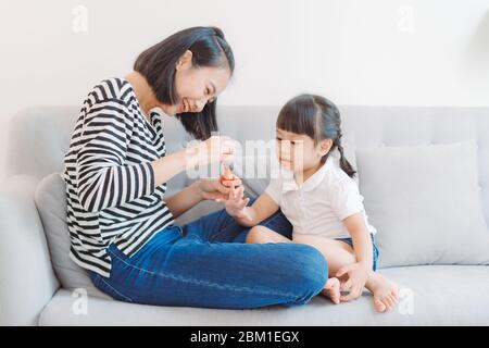 Madre e figlia divertendosi pittura le unghie, famiglia concezione del tempo Foto Stock