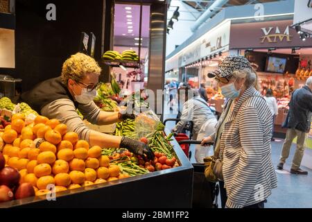 Una donna anziana che indossa una maschera facciale come misura preventiva acquista verdure in mezzo a coronavirus Crisis.The de-escalation del confinamento in Spagna ha ancora una volta riempito i mercati con la gente. Le persone anziane che sono più vulnerabili al virus possono farlo da 10 a 12 al mattino e cogliere l'opportunità di camminare e acquistare cibo che è stato precedentemente fatto da famiglia, amici o ordinato a casa. L'intero paese guarda con cautela in questi giorni e spera che queste partenze non significano una nuova epidemia in poche settimane. Foto Stock