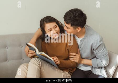 Coppia sorridente cercando romanticamente a ogni altro libro Foto Stock