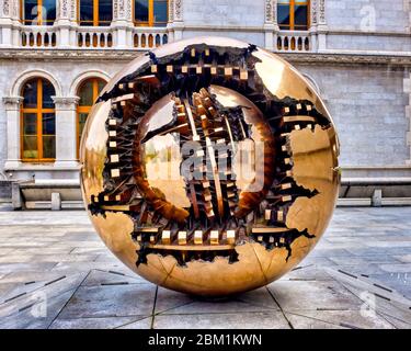 La scultura sfera di Arnaldo Pomodoro all'interno della sfera si trova fuori dalla Berkeley Library del Trinity College, Dublino, Irlanda Foto Stock