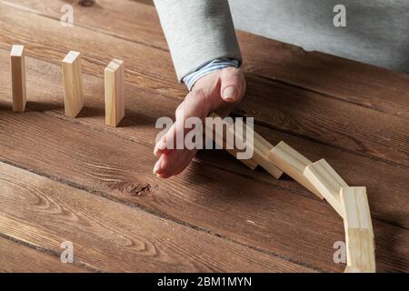 Donna business mano stop effetto domino Foto Stock