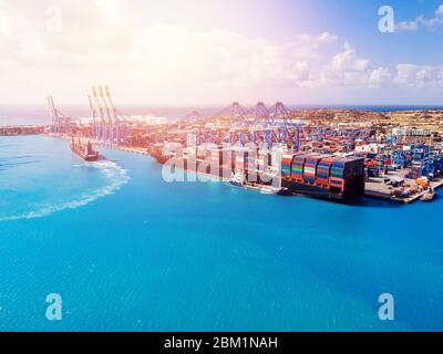 Centro di logistica, centro di affari del porto di carico. La nave sta caricando i container con una gru. Vista aerea. Foto Stock