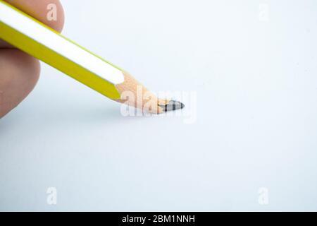 Persona che rompe la punta di un pastelli di legno a strisce gialle e argento Foto Stock