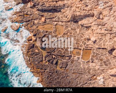 Saline in rocce di costa, antico modo di evaporazione acqua di mare dal sole. Vista dall'alto dell'antenna Foto Stock