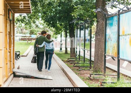 Mosca, Russia - 7 LUGLIO 2017: I giovani e le donne camminano abbracciando il sentiero per il parco oltre i banner con foto alla mostra fotografica della città Foto Stock