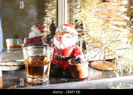 Natale Santa ornamento su mantello con whisky Foto Stock