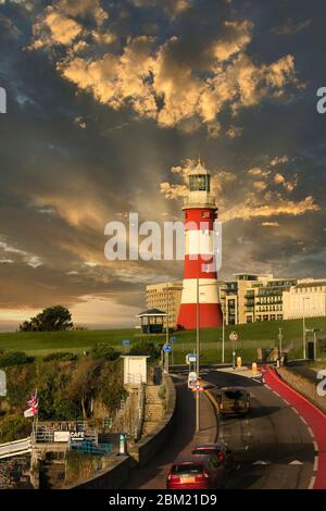 Raggi solari che si rompono attraverso la nuvola all'alba dietro il faro su Plymouth Hoe, Devon, Regno Unito Foto Stock