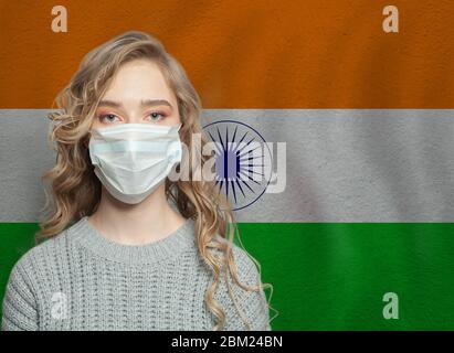 Giovane donna che indossa una maschera protettiva con bandiera nazionale indiana. Influenza epidemica e protezione del virus concetto Foto Stock