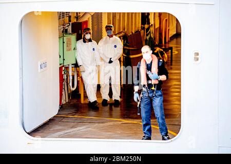 Membri dell'equipaggio che indossano tute protettive come precauzione contro la diffusione del virus corona, dopo che la nave è ancorata.nave da crociera Regal Princess ha ancorato a Rotterdam con circa novecento europei, almeno dieci sono olandesi. La nave restituisce in Europa membri dell'equipaggio provenienti da altre navi da crociera. Per quanto è noto, nessuno è infettato con il virus della corona. Foto Stock