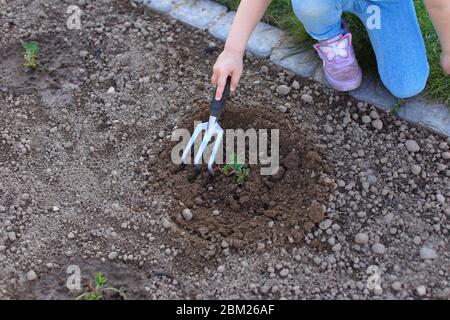 Mamma e figlia lavorano in zoccoli in un giardino Foto Stock