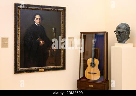 Una chitarra di proprietà del grande chitarrista classico, Andres Segovia, insieme ad un ritratto e busto del chitarrista, nella Accademia reale di San Fernando Foto Stock