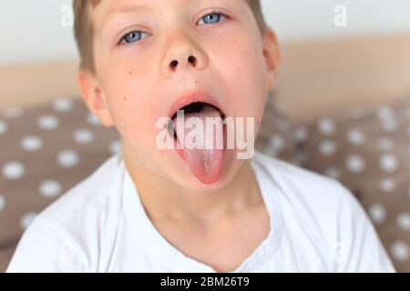Il bambino mostra la sua lunga lingua da vicino Foto Stock