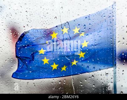 Bandiera europea dietro un pannello di vetro con gocce di pioggia Foto Stock