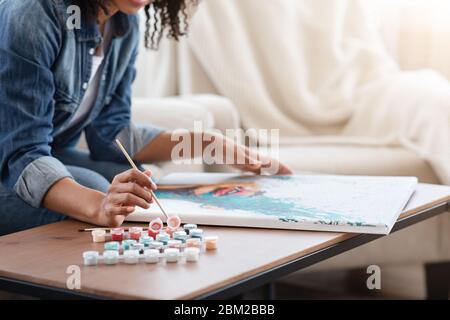 Hobby di quarantena. Immagine di disegno di Donna Africana su tela a casa Foto Stock