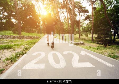 Collage di jogger maschio motivato che corre su percorso con 2021 iscrizioni Foto Stock