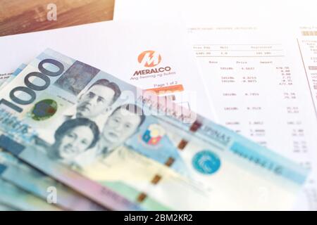 Manila, Filippine - 6 maggio 2020: Banconota in contanti da mille pesos Filippine su carta da disegno di meralco. Concetto di pagamento delle fatture, primo piano. Foto Stock