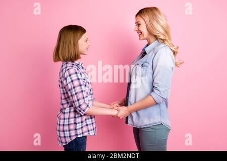 Profilo foto laterale di bello affascinante rimorchio persone madre figlia tenere mano godere di trascorrere il tempo libero fine settimana insieme indossare jeans denim a scacchi plaid Foto Stock