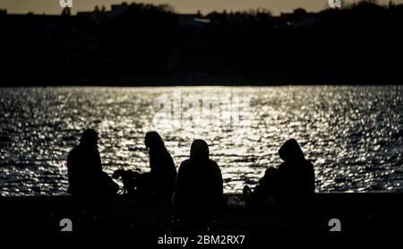 Amburgo, Germania. 06 maggio 2020. La gente siede intorno alle rive dell'Alster esterno al sole della sera. Credit: Axel Heimken/dpa/Alamy Live News Foto Stock