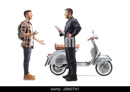 Un'immagine di profilo a tutta lunghezza di un meccanico e di un ragazzo con uno scooter che ha una conversazione isolata su sfondo bianco Foto Stock