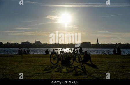 Amburgo, Germania. 06 maggio 2020. Molte persone siedono intorno alle rive dell'Alster esterno al sole della sera. Credit: Axel Heimken/dpa/Alamy Live News Foto Stock