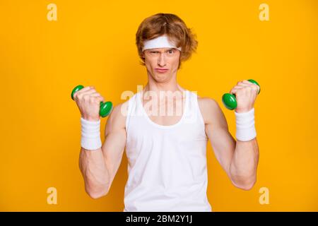 Ritratto primo piano del suo bel ragazzo attraente motivato facendo il lavoro con piccolo dumbbell auto sviluppare resistenza isolato sopra Foto Stock