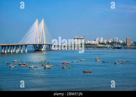 Bandra - Worli Sea link ponte con vista barche da pesca dal forte Bandra. Mumbai, India Foto Stock