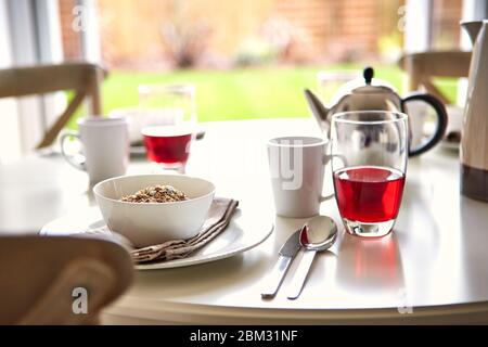 La colazione è servita ogni mattina con caffè nero caldo e una tazza di cereali sul tavolo Foto Stock