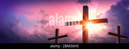 Tre croci di legno con Alba e nuvole sfondo - morte e risurrezione di Gesù Cristo Foto Stock