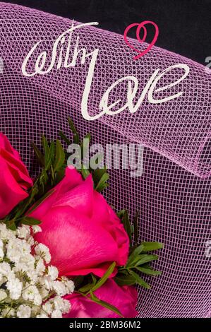 Biglietto per le vacanze - un bouquet di rose rosse fresche in un pacchetto festivo, auguri di vacanza, iscrizione manoscritta con un pennello, scritta di saluto. Foto Stock